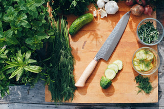 cutting board with fresh herbs and a knife